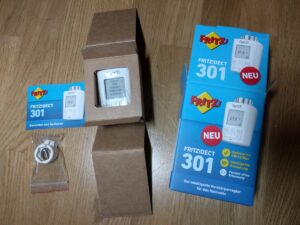 FRITZ!DECT 301 ausgepackt: links Anleitung und Adapter, mittig das Thermostat und rechts die Verpackung